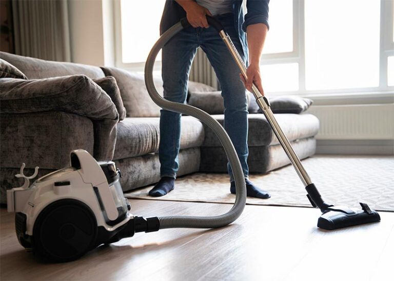 man vacuums the floor